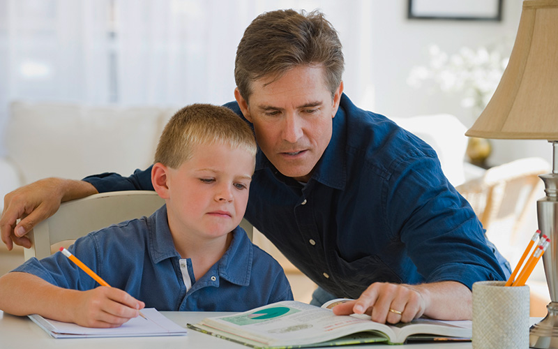 father helping son with school work