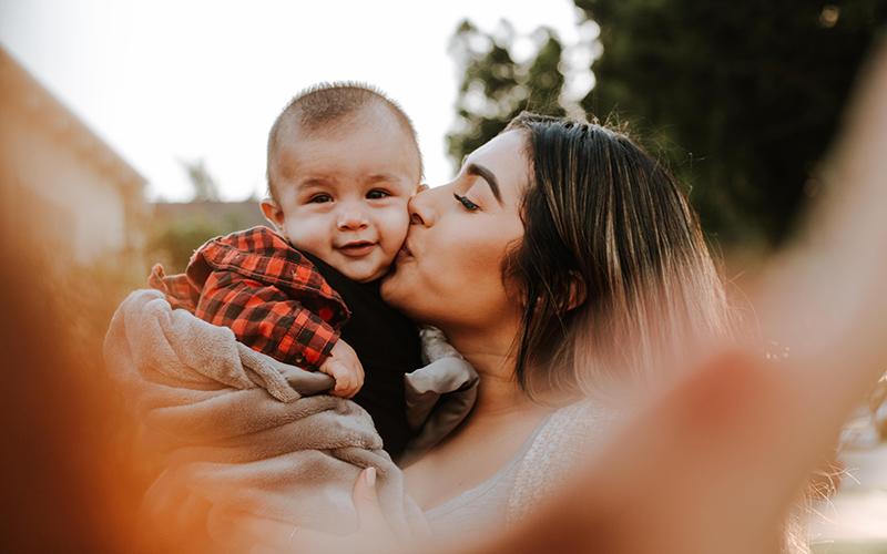 Woman kissing her child